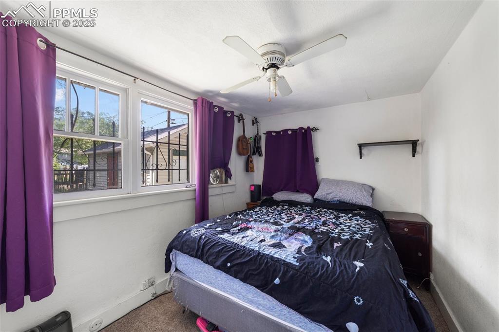 Image 15 of 31: Carpeted bedroom with baseboards and ceiling fan