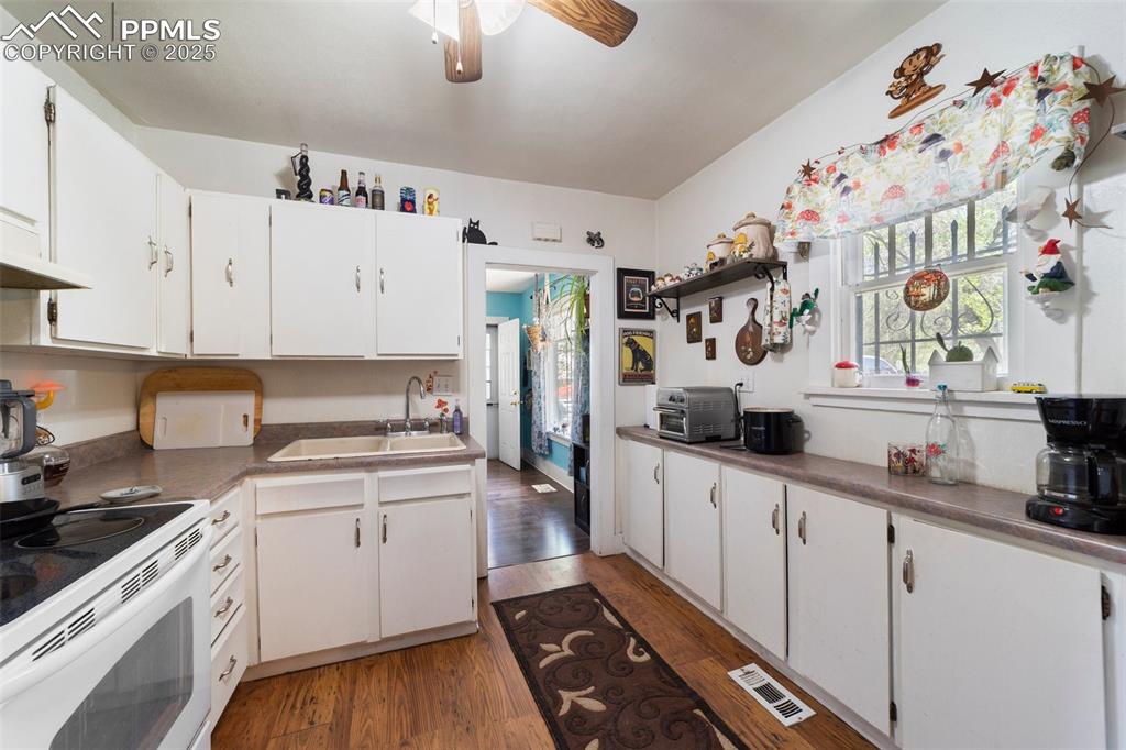 Image 3 of 31: Kitchen with a sink, white electric range oven, wood finished floors, ceili
