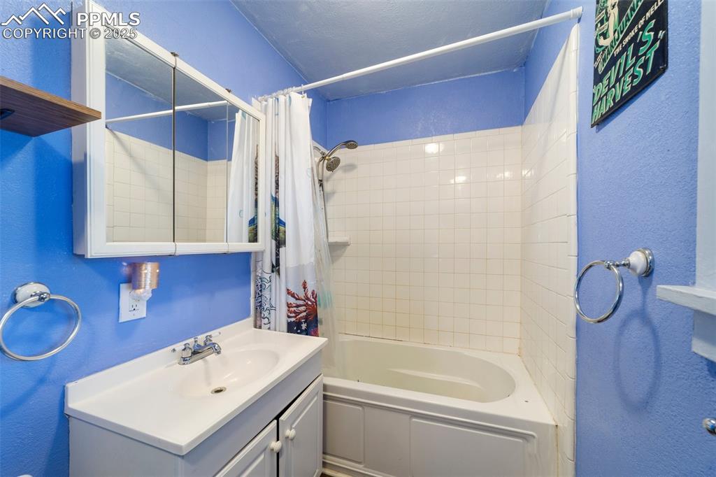 Image 31 of 31: Bathroom featuring vanity, shower / tub combo, and a textured wall