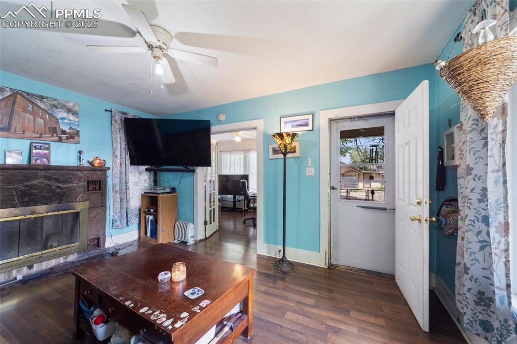 Image 4 of 31: Living room with a ceiling fan, wood finished floors, a glass covered firep