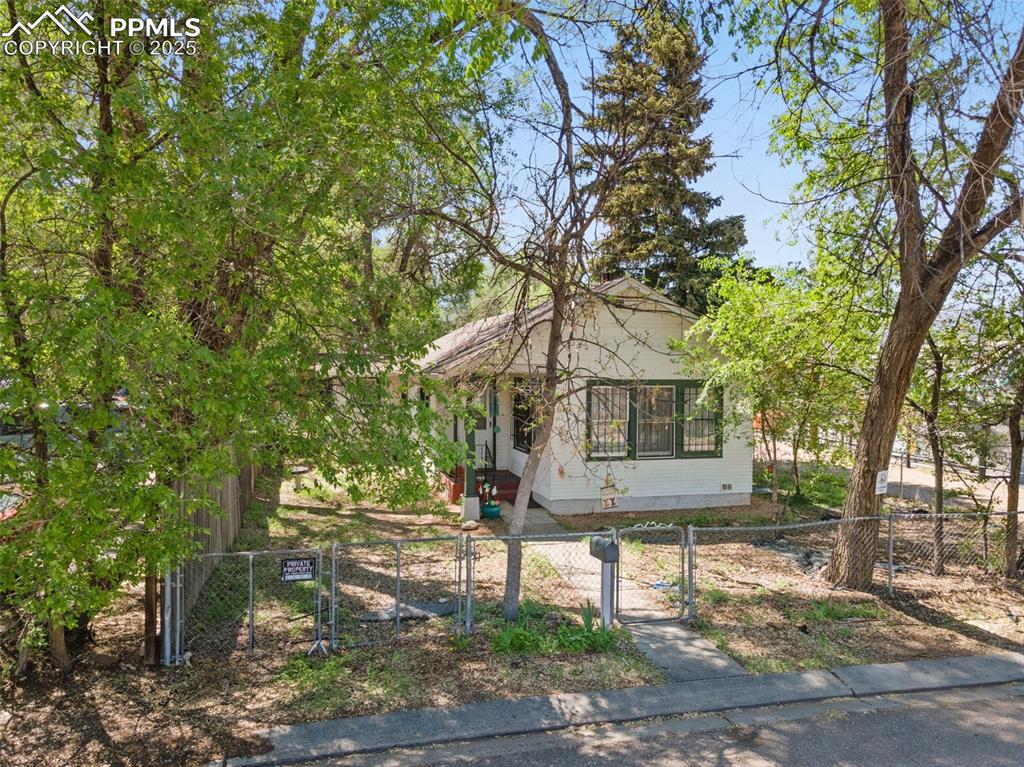 Image 9 of 31: View of front of home featuring a gate, a fenced front yard, and crawl spac