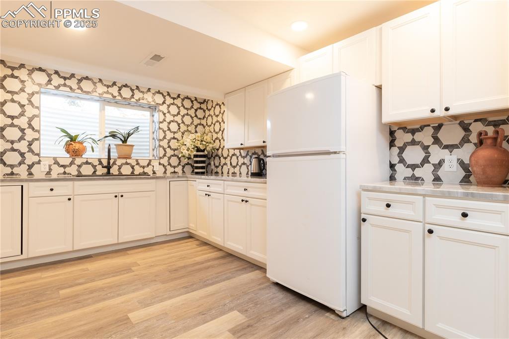 Image 21 of 49: Lower level kitchen with full height tile backsplash