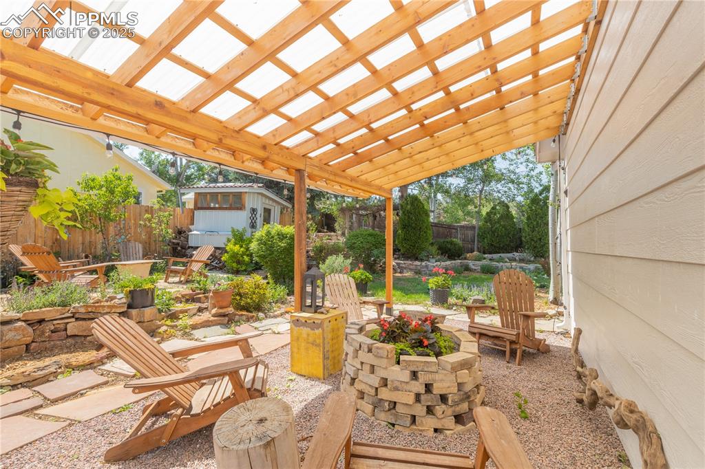 Image 30 of 49: Flagstone patio with firepit and Pergola.