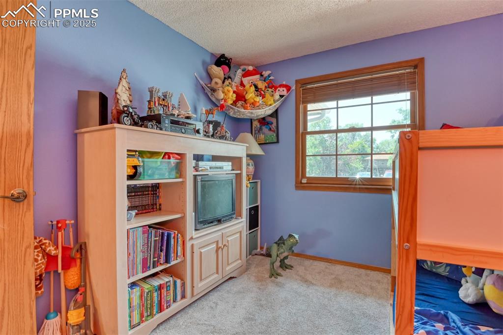 Image 19 of 32: Carpeted bedroom featuring a textured ceiling and baseboards