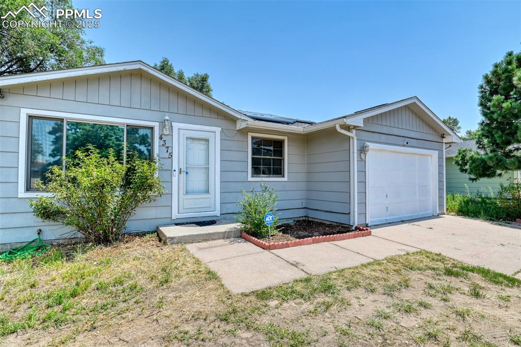 Image 2 of 32: Ranch-style house featuring an attached garage, roof mounted solar panels, 