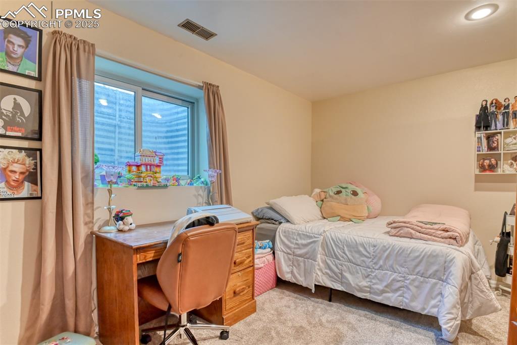 Image 26 of 32: Carpeted bedroom with an office area