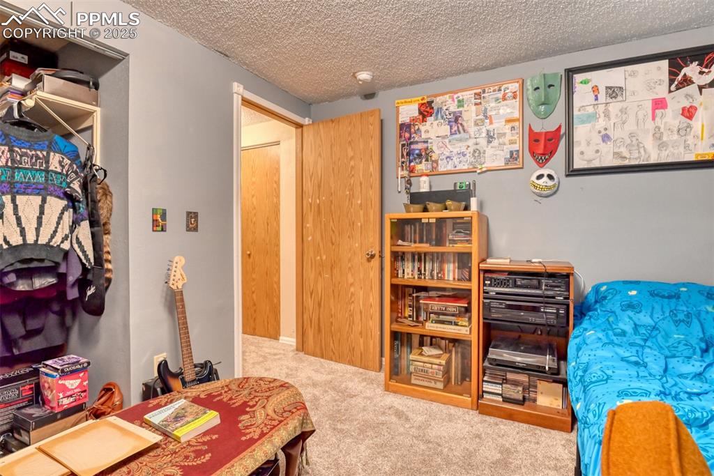 Image 31 of 32: Bedroom featuring a textured ceiling and carpet flooring