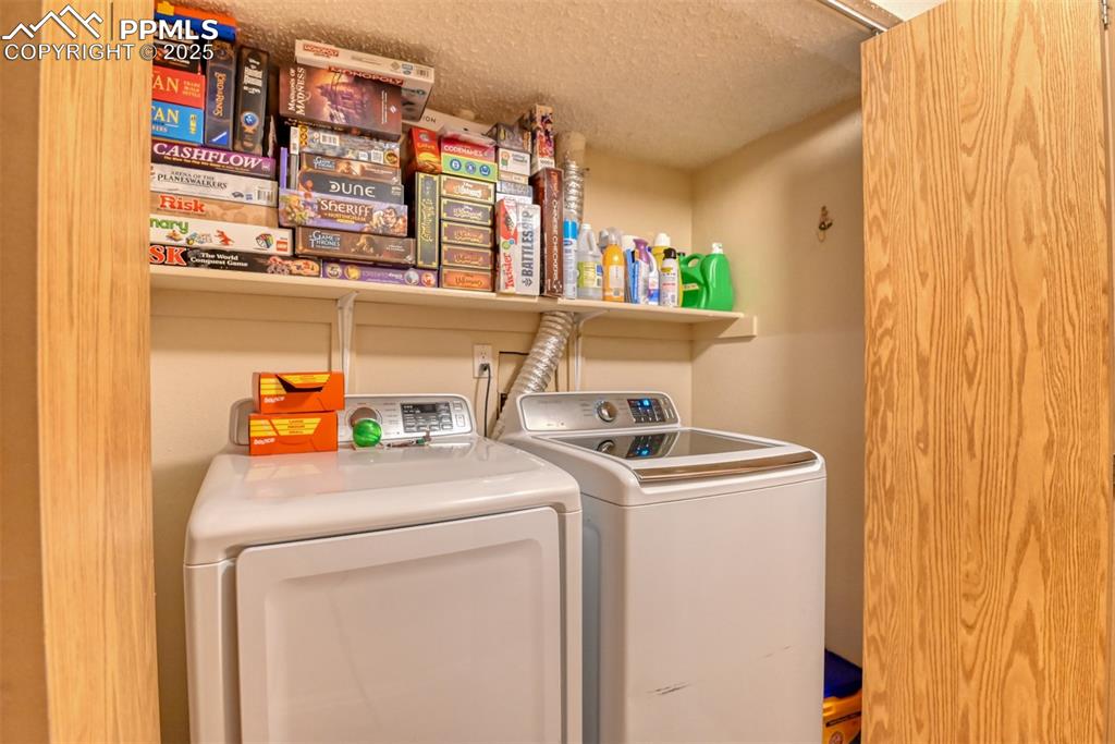 Image 32 of 32: Washroom with washing machine and clothes dryer and a textured ceiling