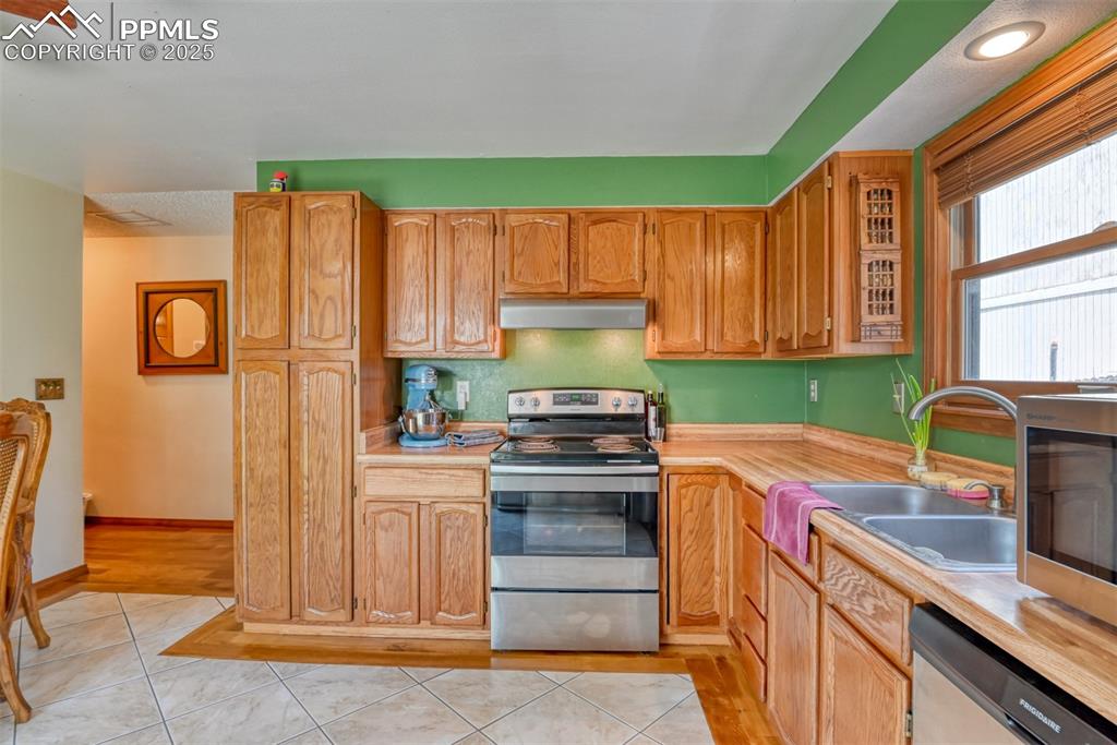 Image 9 of 32: Kitchen featuring stainless steel appliances, light countertops, under cabi