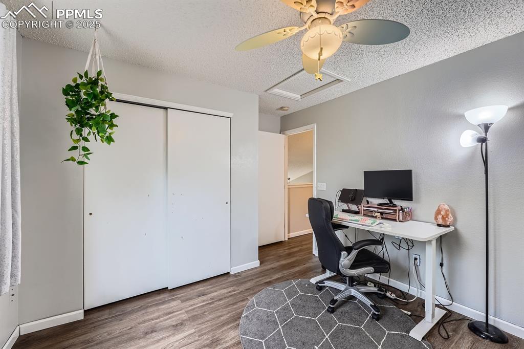 Image 19 of 28: Office area with wood finished floors, a ceiling fan, and a textured ceilin