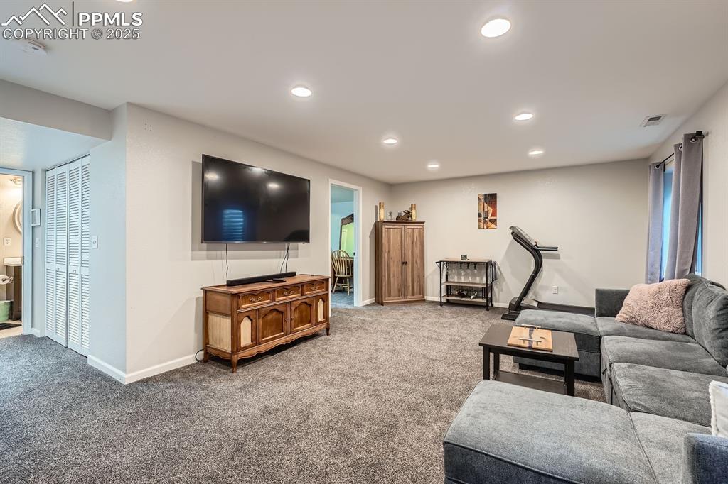 Image 20 of 28: Living area with carpet floors and recessed lighting