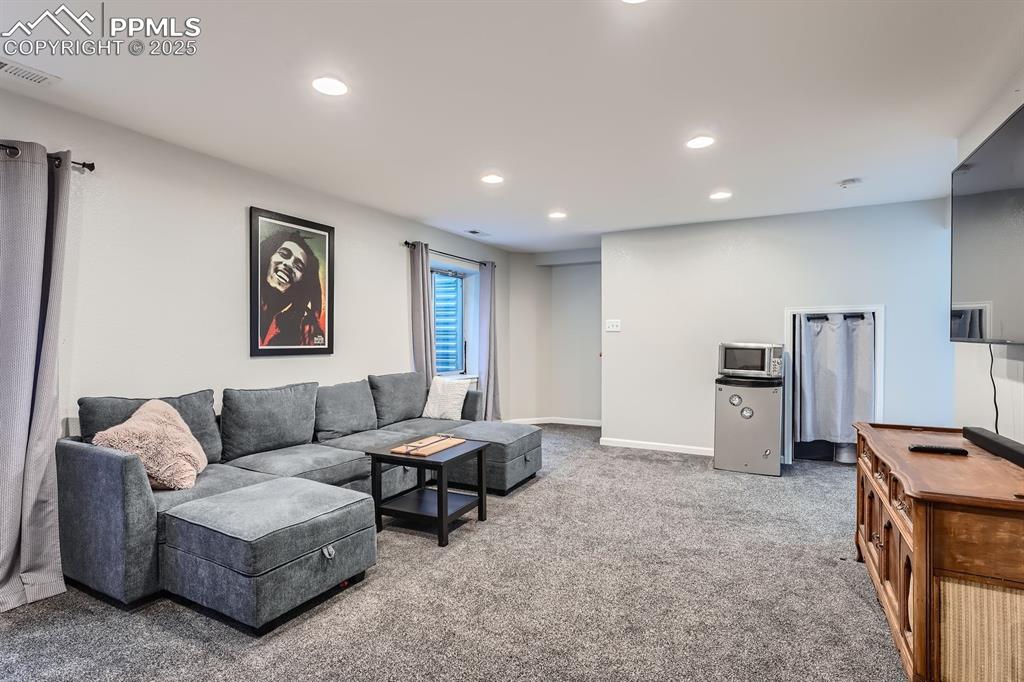 Image 21 of 28: Carpeted living area with recessed lighting