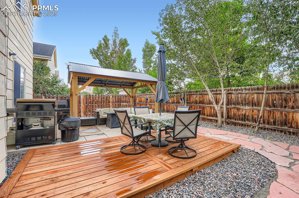 Image 25 of 28: Wooden deck with a gazebo, outdoor dining area, area for grilling, a fenced