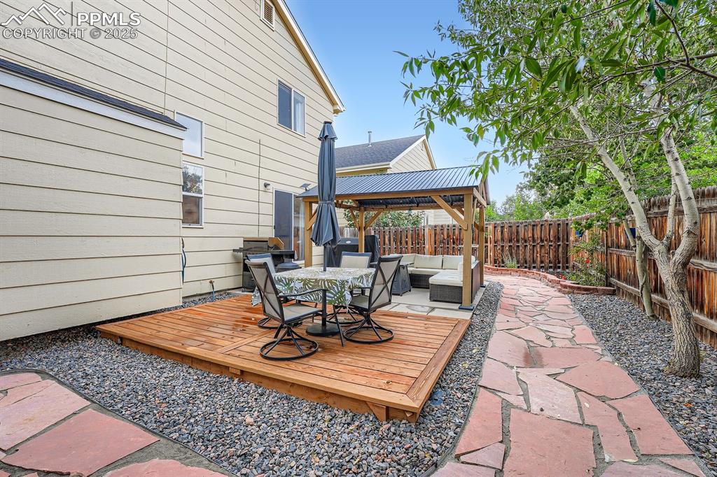 Image 28 of 28: Wooden terrace featuring a gazebo, a fenced backyard, an outdoor living spa