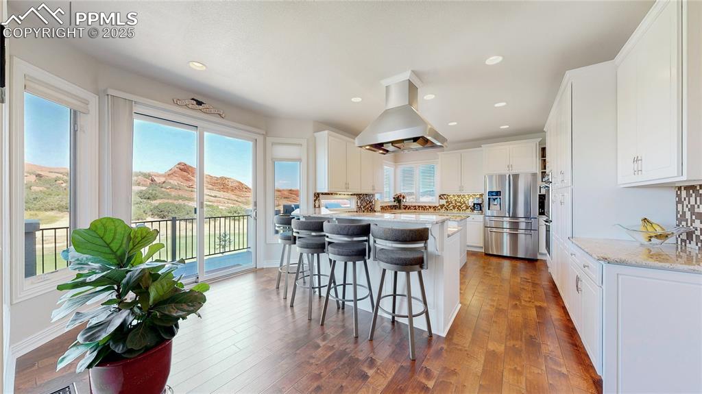 Image 10 of 46: Kitchen featuring tasteful backsplash, a breakfast bar area, light stone co
