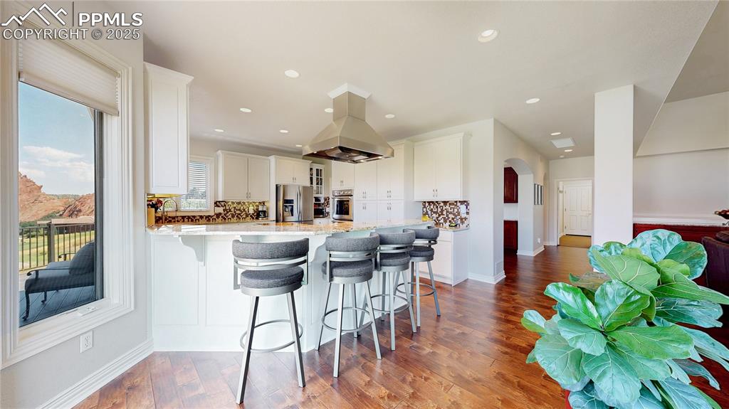 Image 11 of 46: Kitchen with a peninsula, arched walkways, a breakfast bar area, decorative