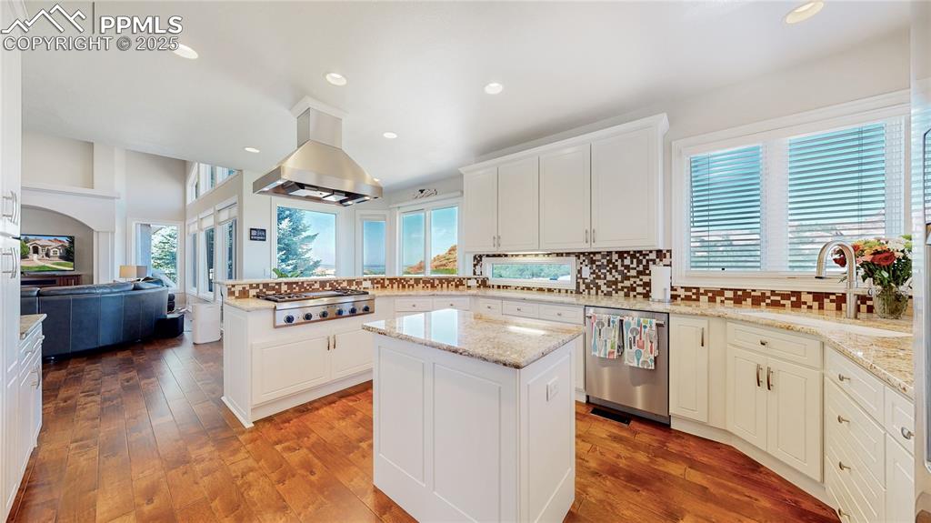 Image 12 of 46: Kitchen with recessed lighting, decorative backsplash, stainless steel appl