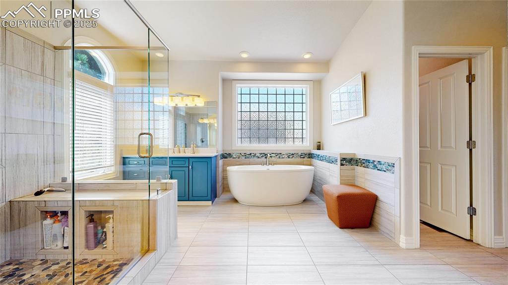 Image 17 of 46: Bathroom featuring tile walls, plenty of natural light, a freestanding tub,