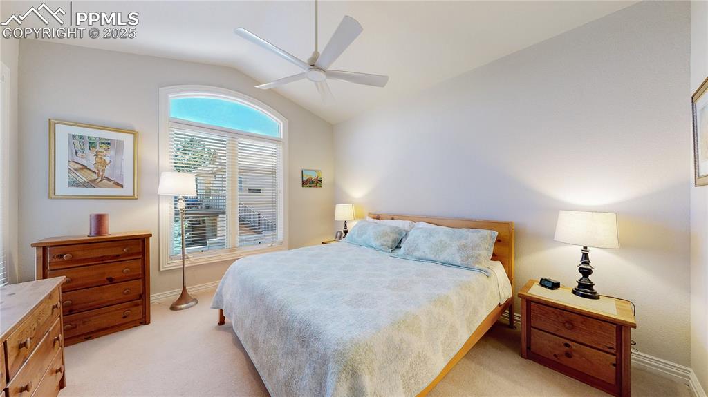 Image 19 of 46: Bedroom featuring lofted ceiling, light carpet, and ceiling fan