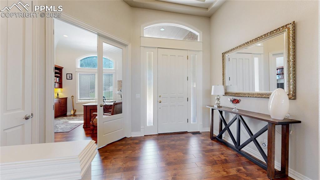 Image 3 of 46: Foyer entrance with dark wood-style floors and baseboards
