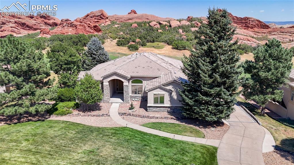 Image 41 of 46: View of front of home featuring stone siding, a front yard, and a mountain 