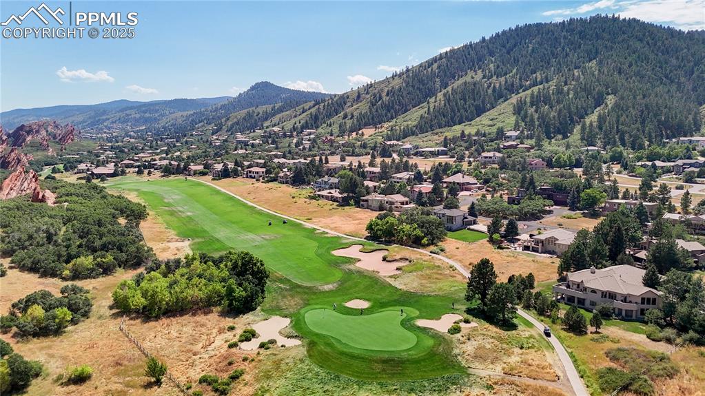 Image 46 of 46: Aerial perspective of suburban area featuring a local golf course and a mou