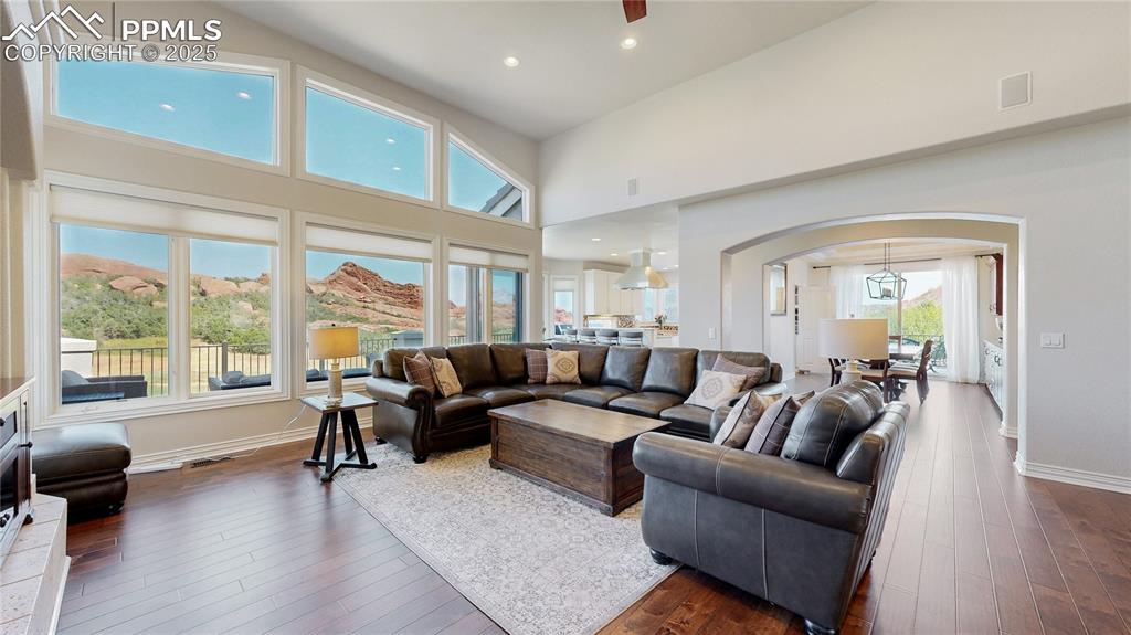 Image 6 of 46: Living room with arched walkways, recessed lighting, wood-type flooring, a 
