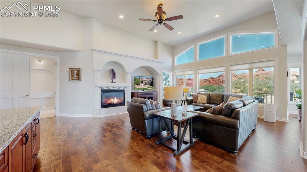 Image 7 of 46: Living room with a towering ceiling, dark wood-type flooring, recessed ligh