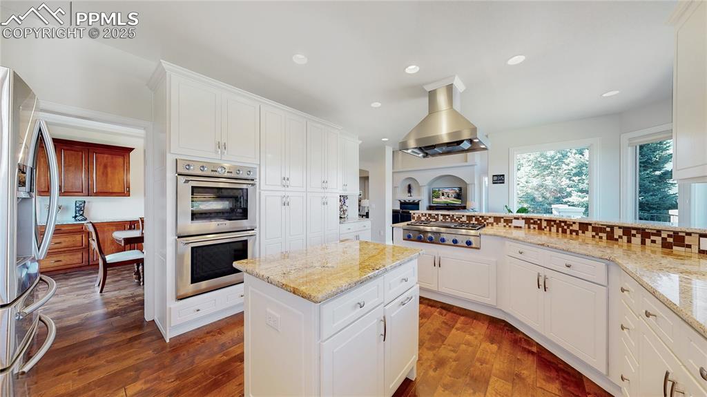 Image 9 of 46: Kitchen with light stone countertops, appliances with stainless steel finis