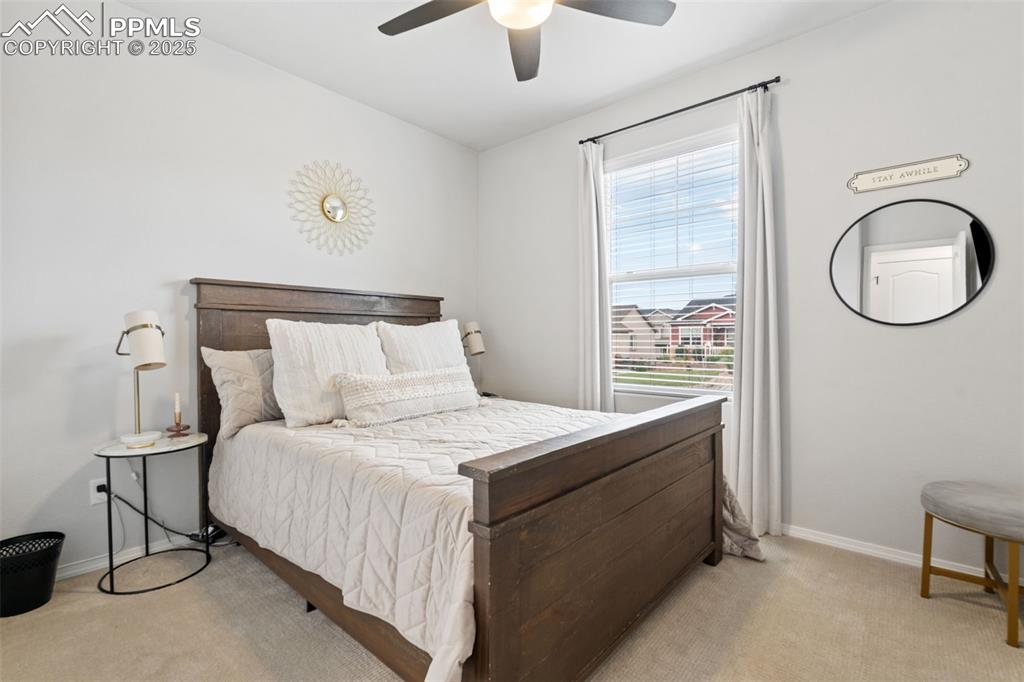 Image 13 of 22: Bedroom with light colored carpet and ceiling fan