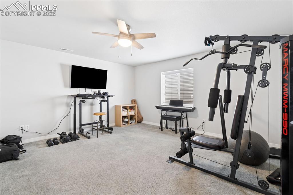 Image 17 of 22: Workout area featuring a ceiling fan and carpet flooring
