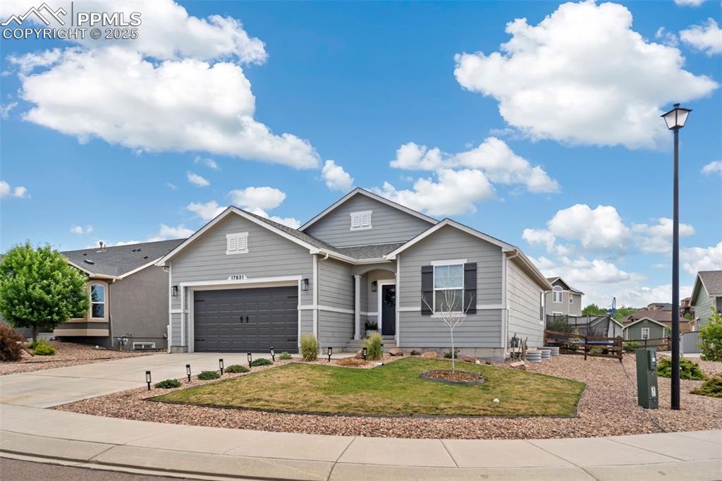 Image 2 of 22: View of front of home with driveway, a garage, and a front yard