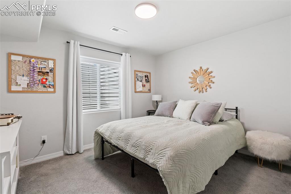 Image 20 of 22: Bedroom with light carpet and baseboards