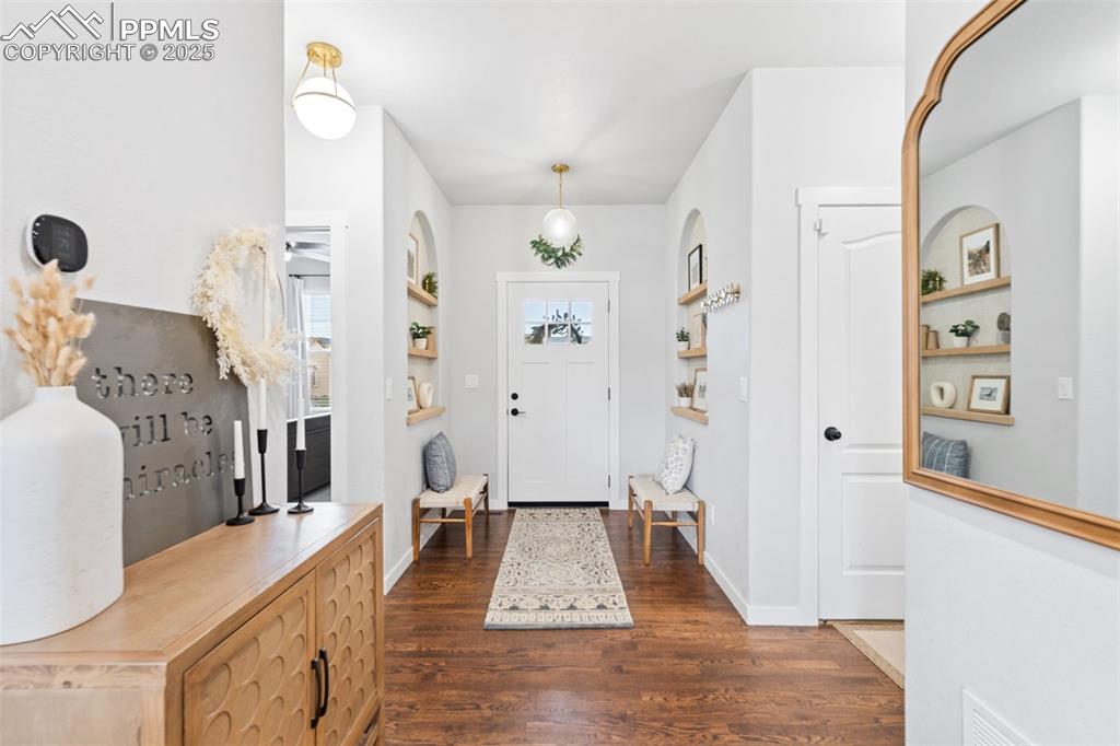 Image 3 of 22: Foyer entrance featuring dark wood finished floors and baseboards