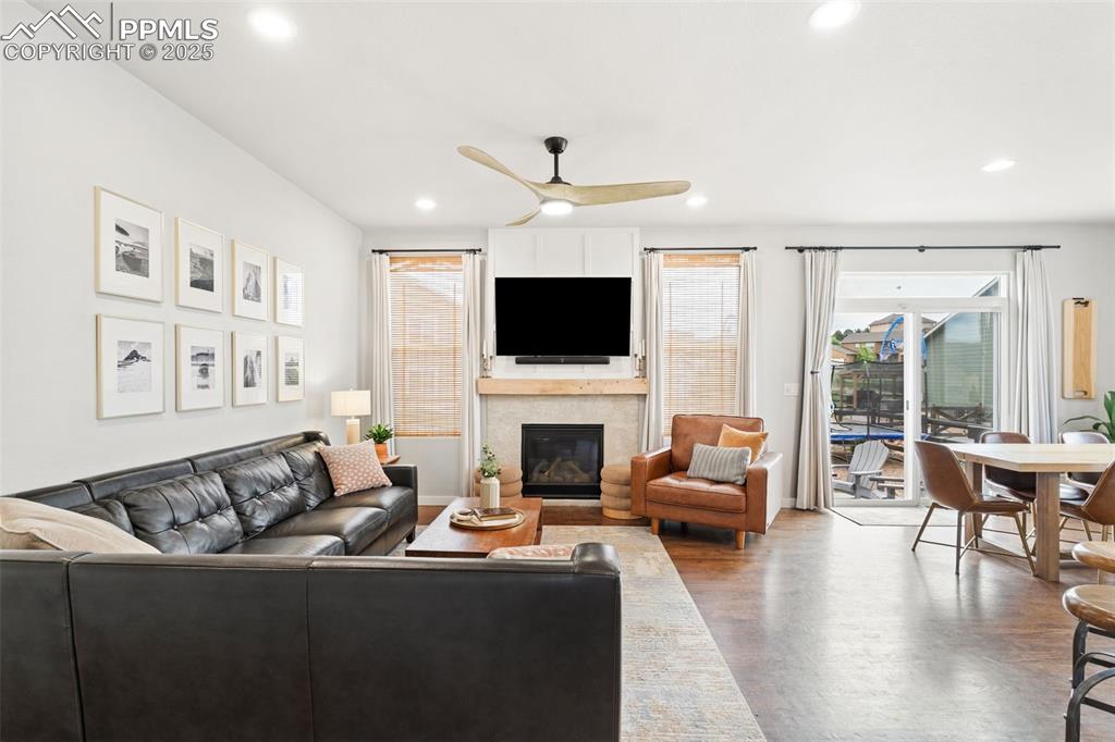 Image 4 of 22: Living area with a ceiling fan, a glass covered fireplace, and recessed lig