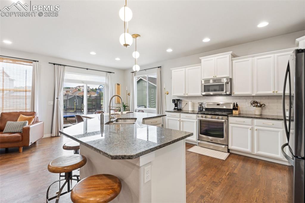 Image 8 of 22: Kitchen featuring appliances with stainless steel finishes, dark wood-style
