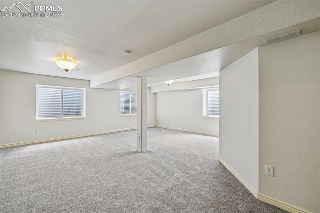 Image 30 of 46: Basement featuring carpet floors and a textured ceiling