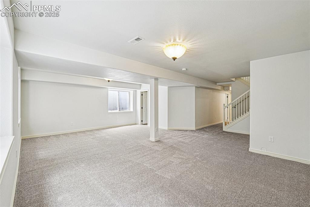 Image 32 of 46: Basement with carpet floors and stairway