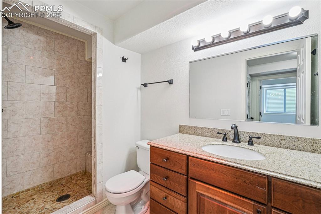 Image 38 of 46: Bathroom with vanity and a tile shower