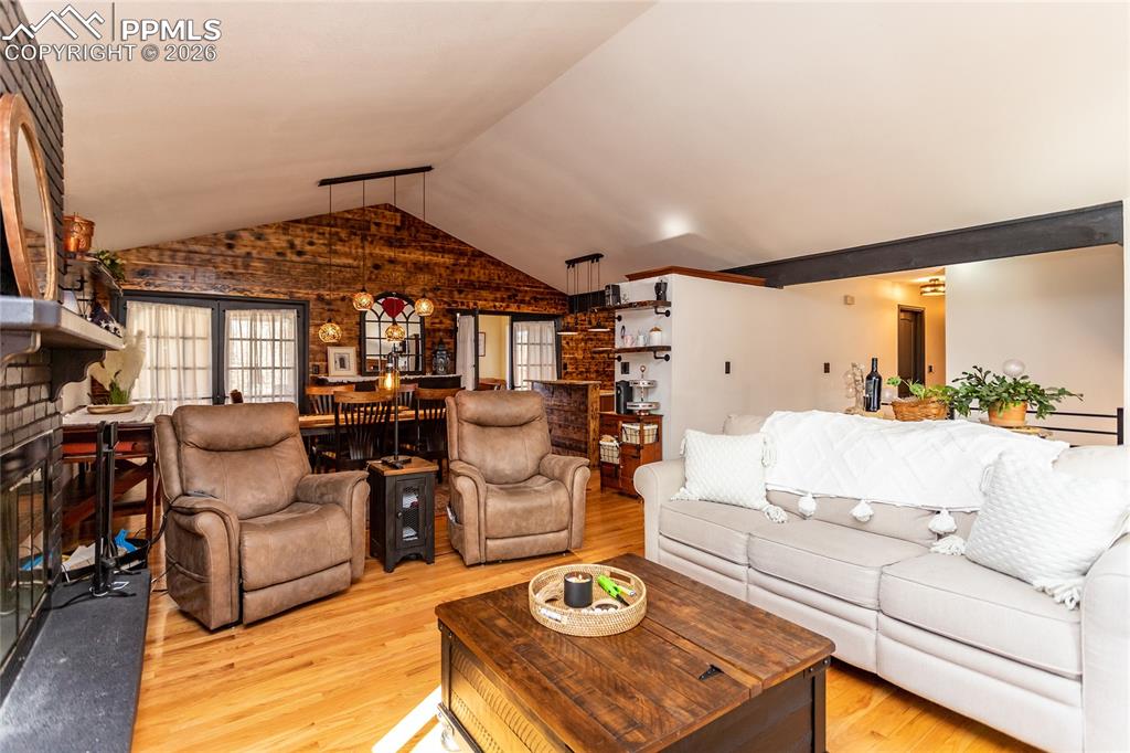 Image 14 of 50: Open living area, vaulted ceiling.