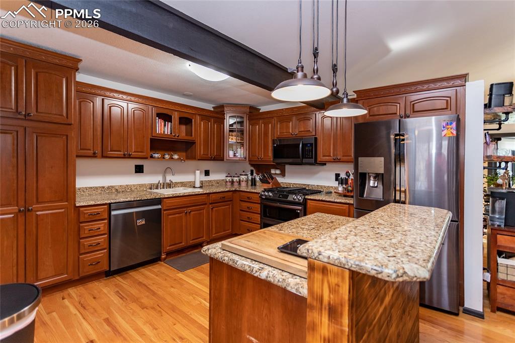 Image 22 of 50: Stainless steel appliances including gas stove.