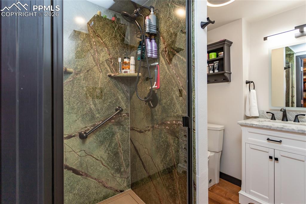 Image 43 of 50: Downstairs bathroom with beautiful tiled shower.