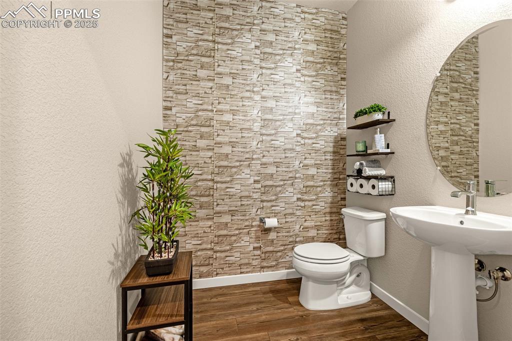 Image 10 of 35: Bathroom with a textured wall and dark wood-type flooring