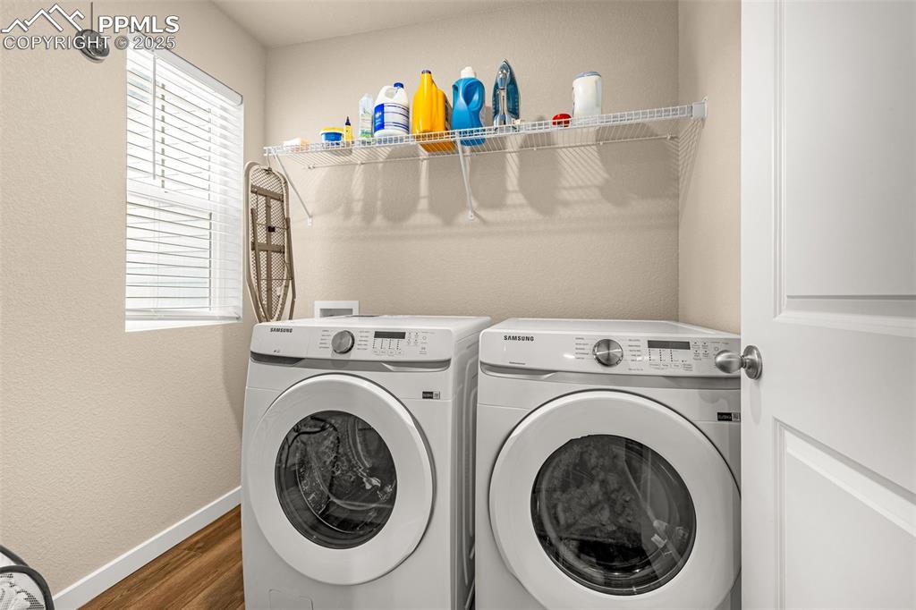 Image 16 of 35: Washroom with a textured wall, dark wood-type flooring, and washer and drye