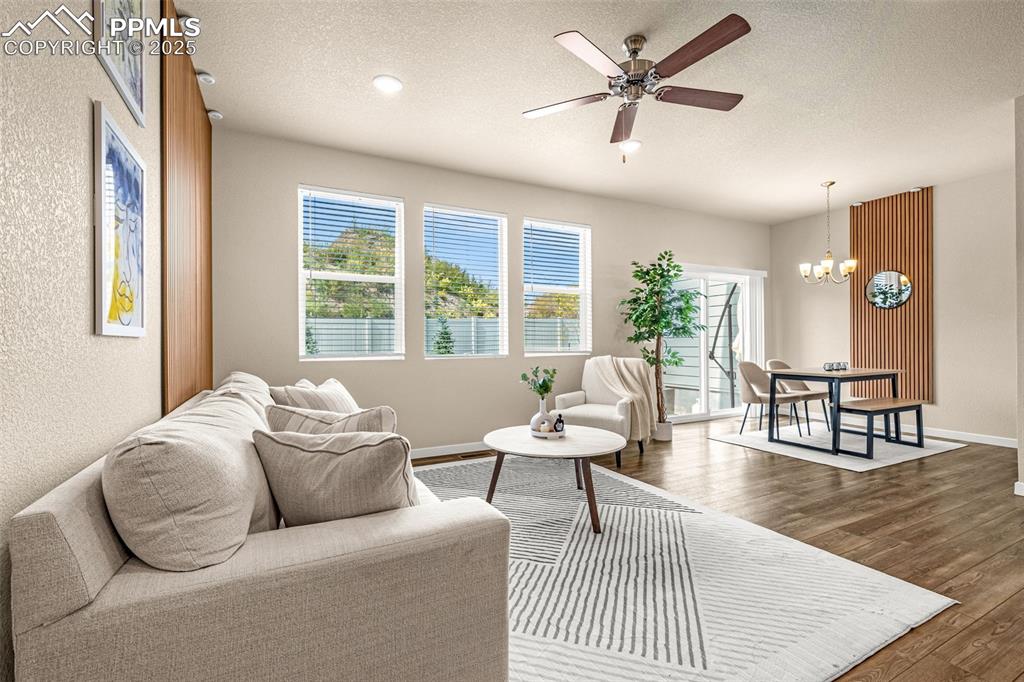 Image 2 of 35: Living area featuring a textured ceiling, wood finished floors, a ceiling f
