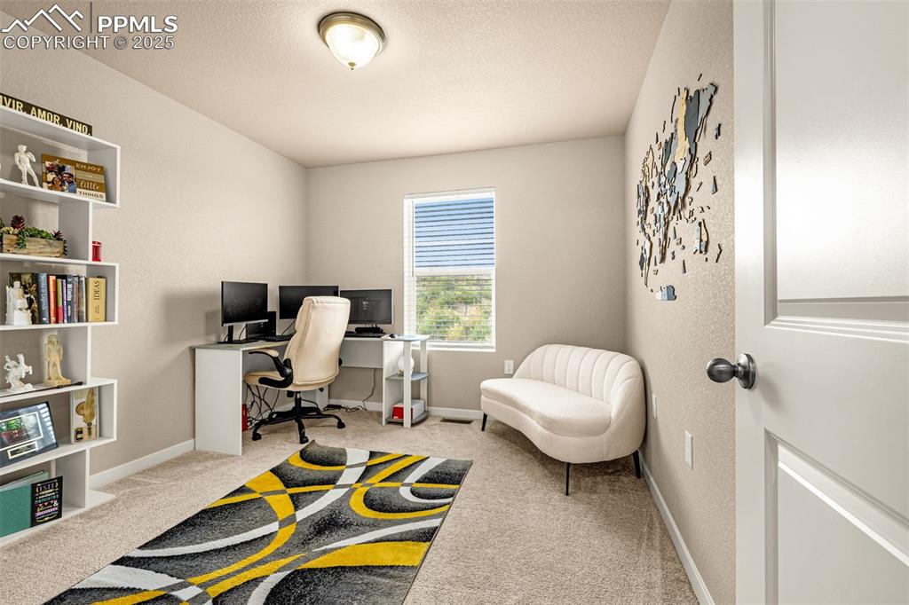 Image 21 of 35: Office area with light carpet and a textured ceiling