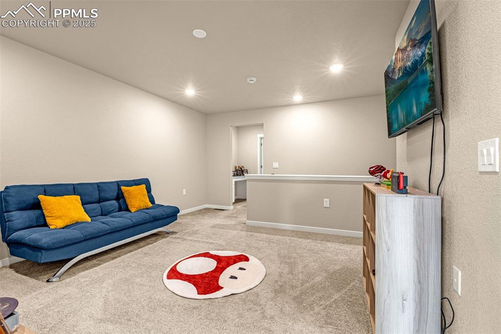 Image 22 of 35: Playroom with light colored carpet, recessed lighting, and a textured wall
