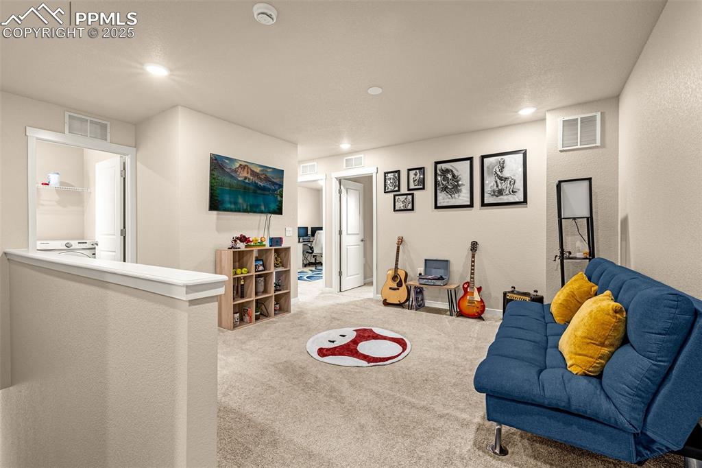 Image 23 of 35: Carpeted living room featuring recessed lighting and a textured wall