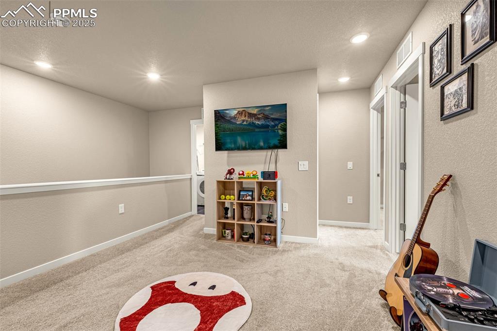 Image 25 of 35: Rec room featuring a textured wall, light colored carpet, and recessed ligh