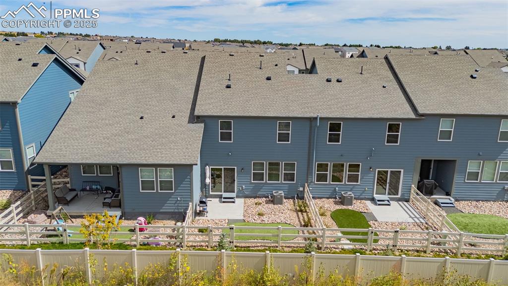 Image 31 of 35: Rear view of house featuring a patio, a shingled roof, and a fenced backyar